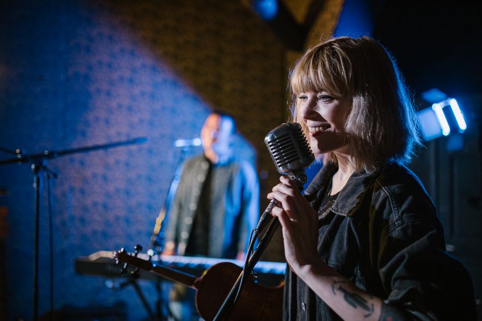 Live music performer on a lit stage at a major UK concert venue