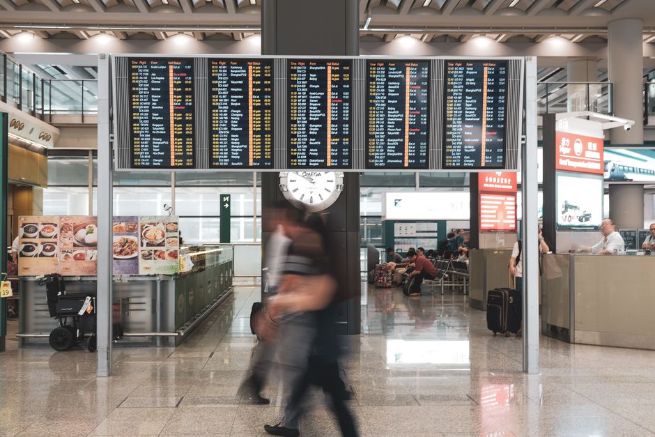 Traveller checking a phone for last-minute UK ETA approval at an airport departure gate