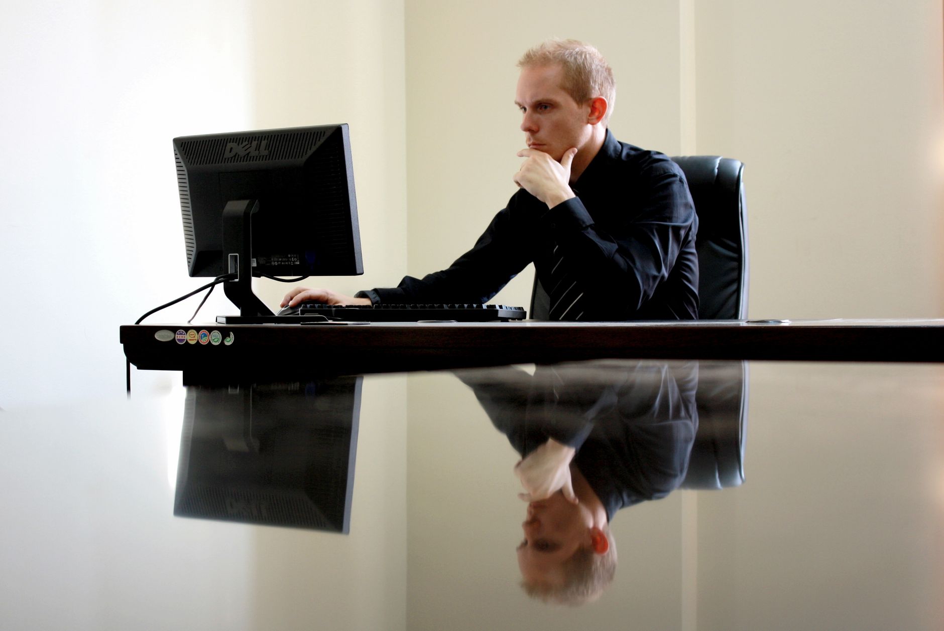 Office worker at a computer arranging travel authorisations for colleagues