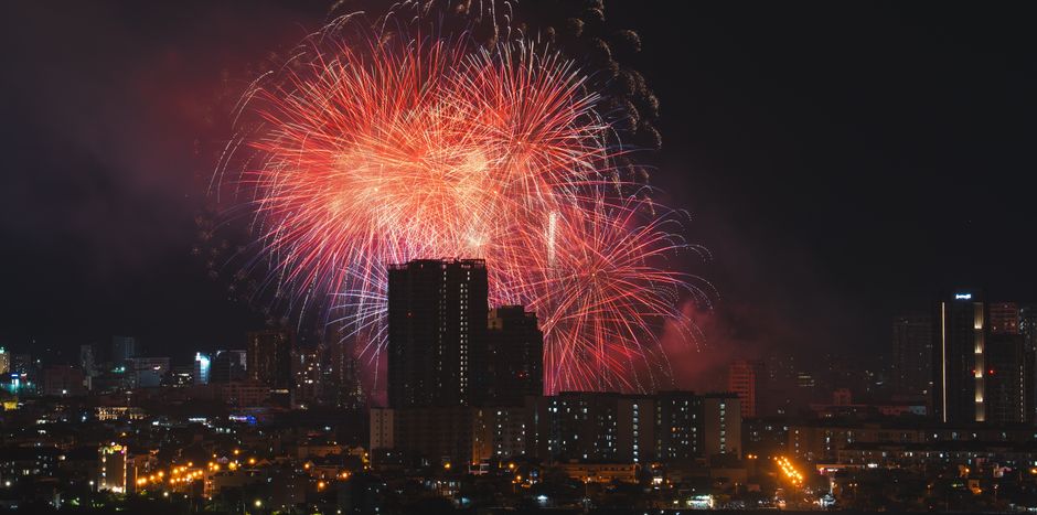 Colourful firework display lighting up the night sky above London rooftops