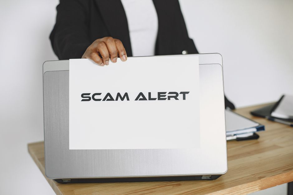 Warning sign on a laptop screen representing UK ETA scam and fraud red flags
