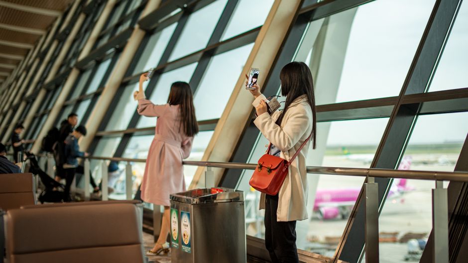 Traveller checking UK ETA approval status on a phone before an airport departure